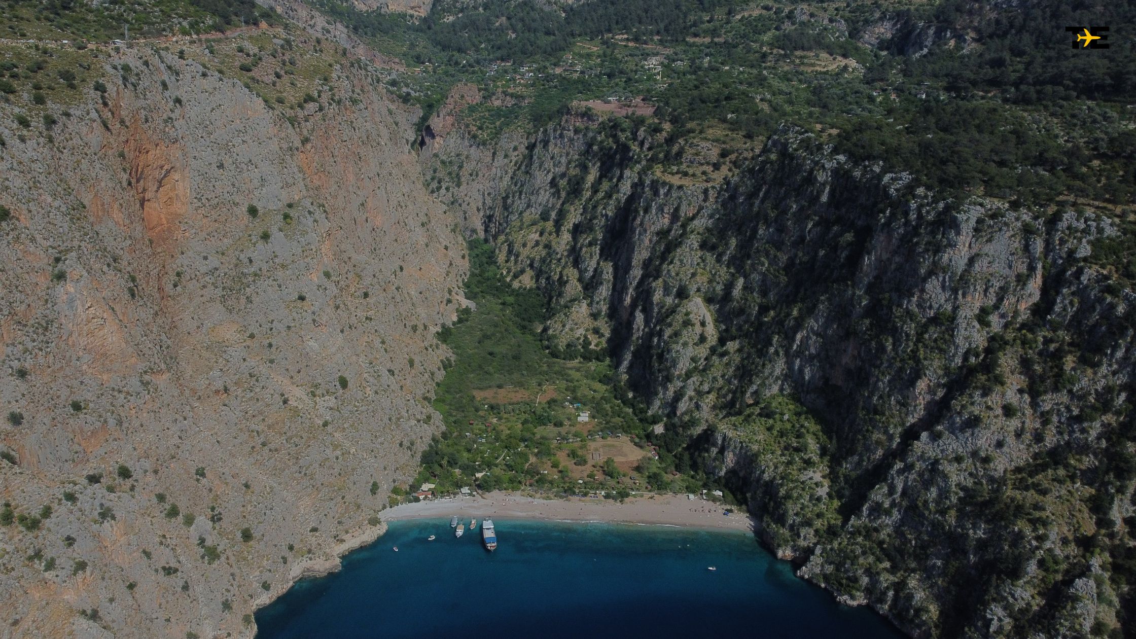 Secluded Butterfly Valley features stunning cliffs, turquoise waters, and a tranquil golden beach.