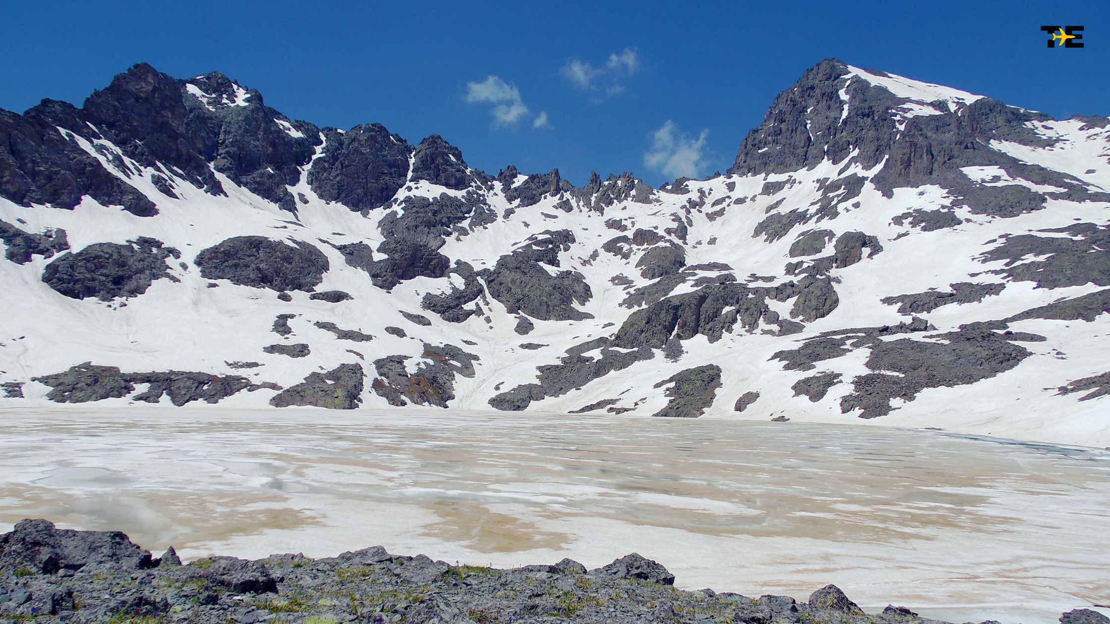 Majestic Kackar Mountains showcase rugged peaks, snow, and a serene glacial lake.