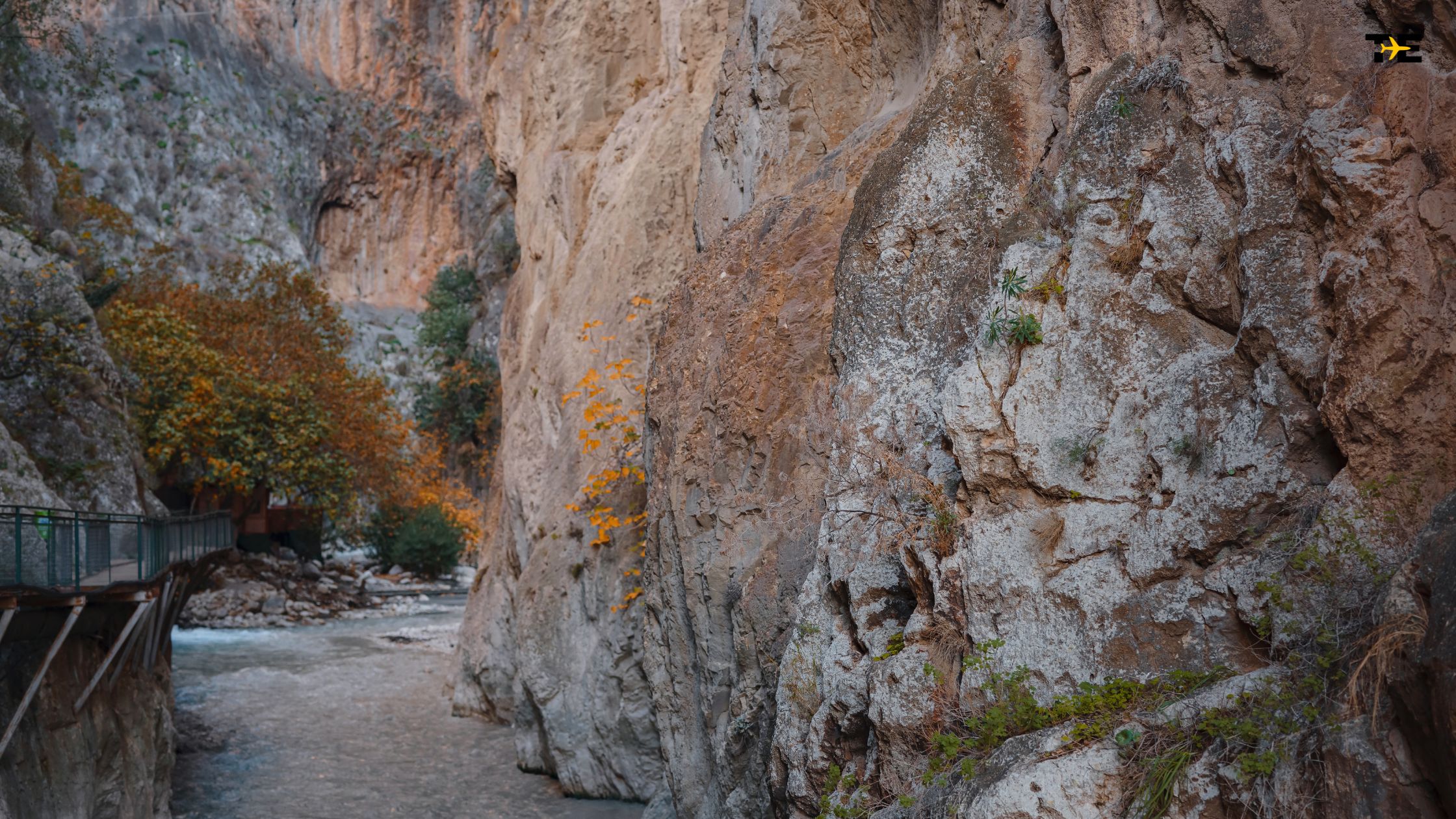 Breathtaking Saklikent Gorge features stunning rock formations, a winding river, and vibrant autumn foliage.