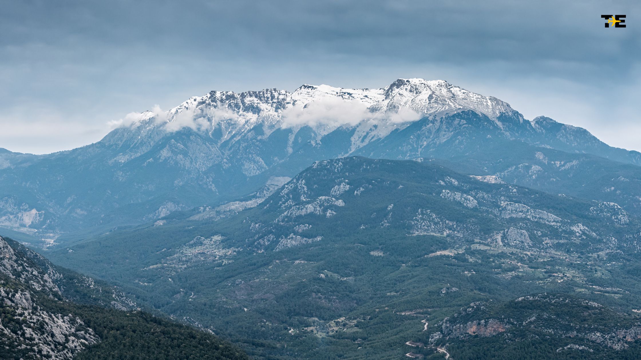 Breathtaking Taurus Mountains showcase snow-capped peaks, lush valleys, and dramatic skies in serene beauty.