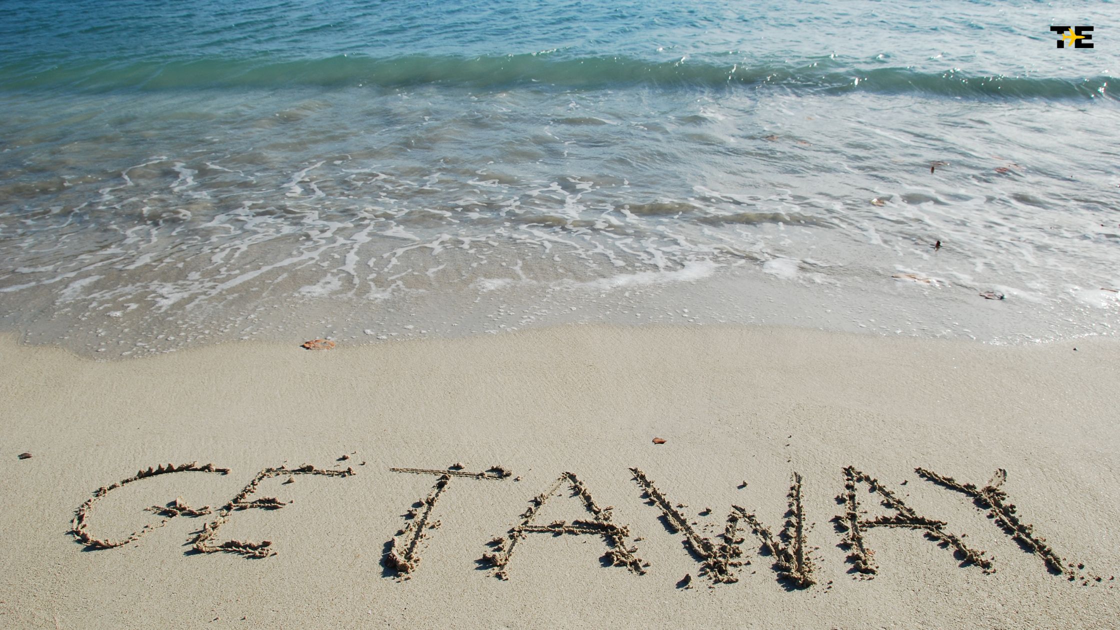 Relax at a serene beach with GET AWAY written in sand, inviting tranquility and escape.