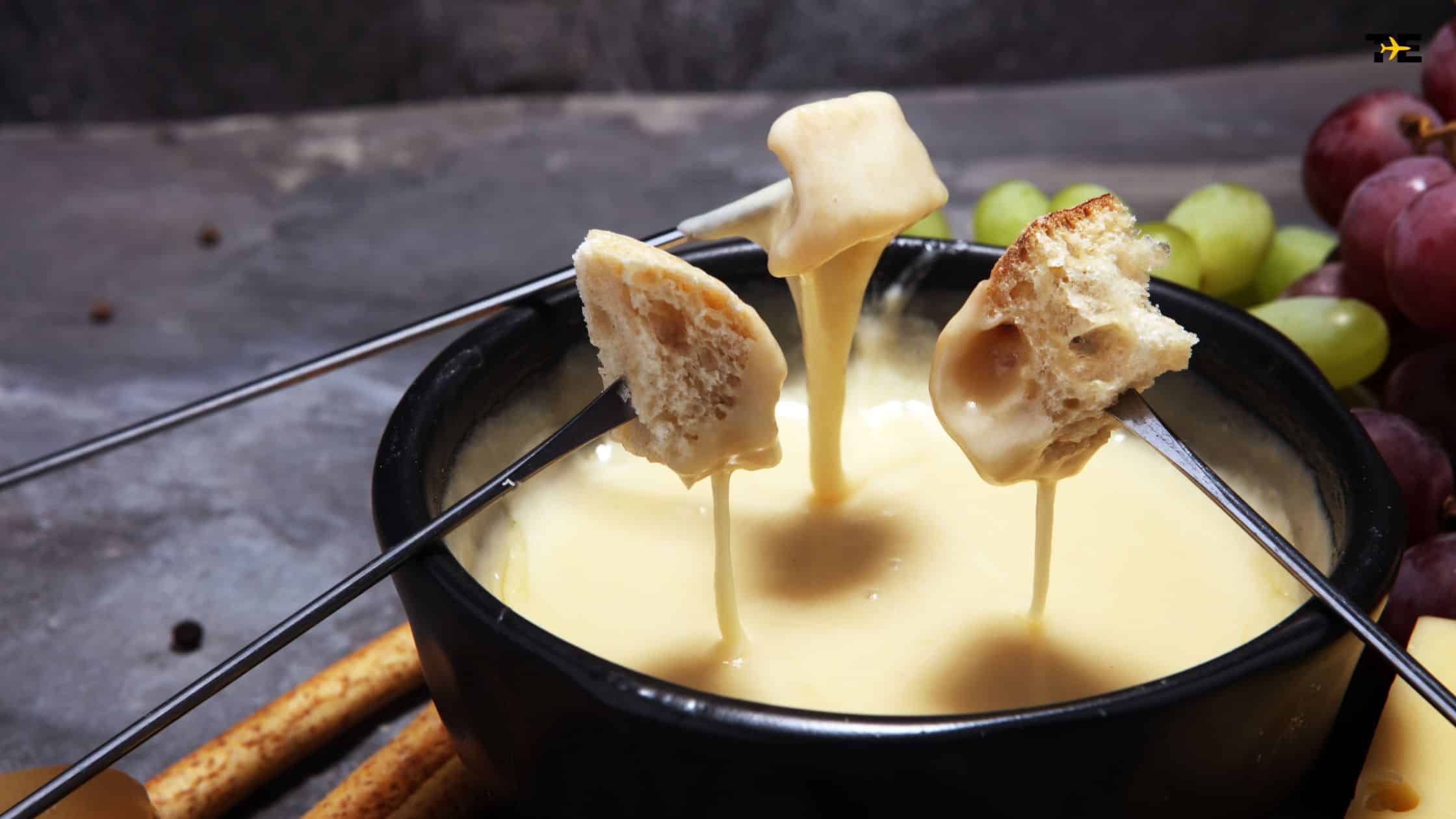 Indulgent cheese fondue pot with breadsticks and fresh grapes, perfect for sharing.