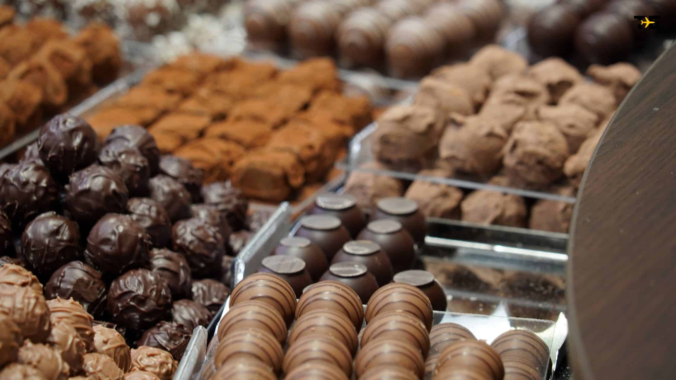 Assorted gourmet chocolate truffles and confections displayed elegantly in a transparent tray.