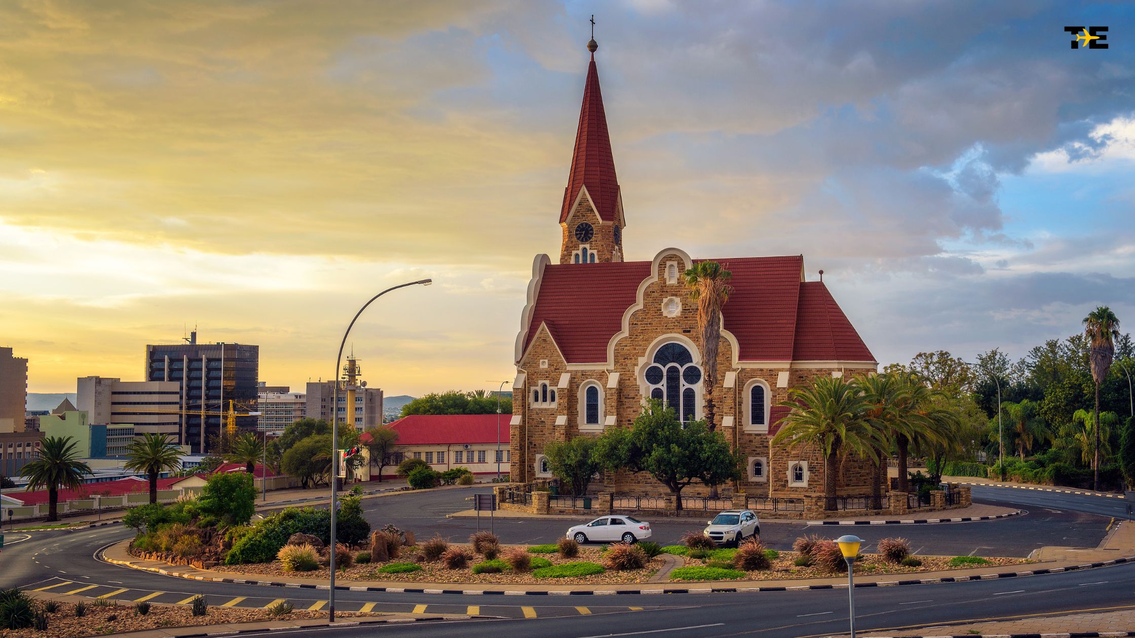 Stunning church at sunset, blending traditional architecture with a modern urban skyline backdrop.