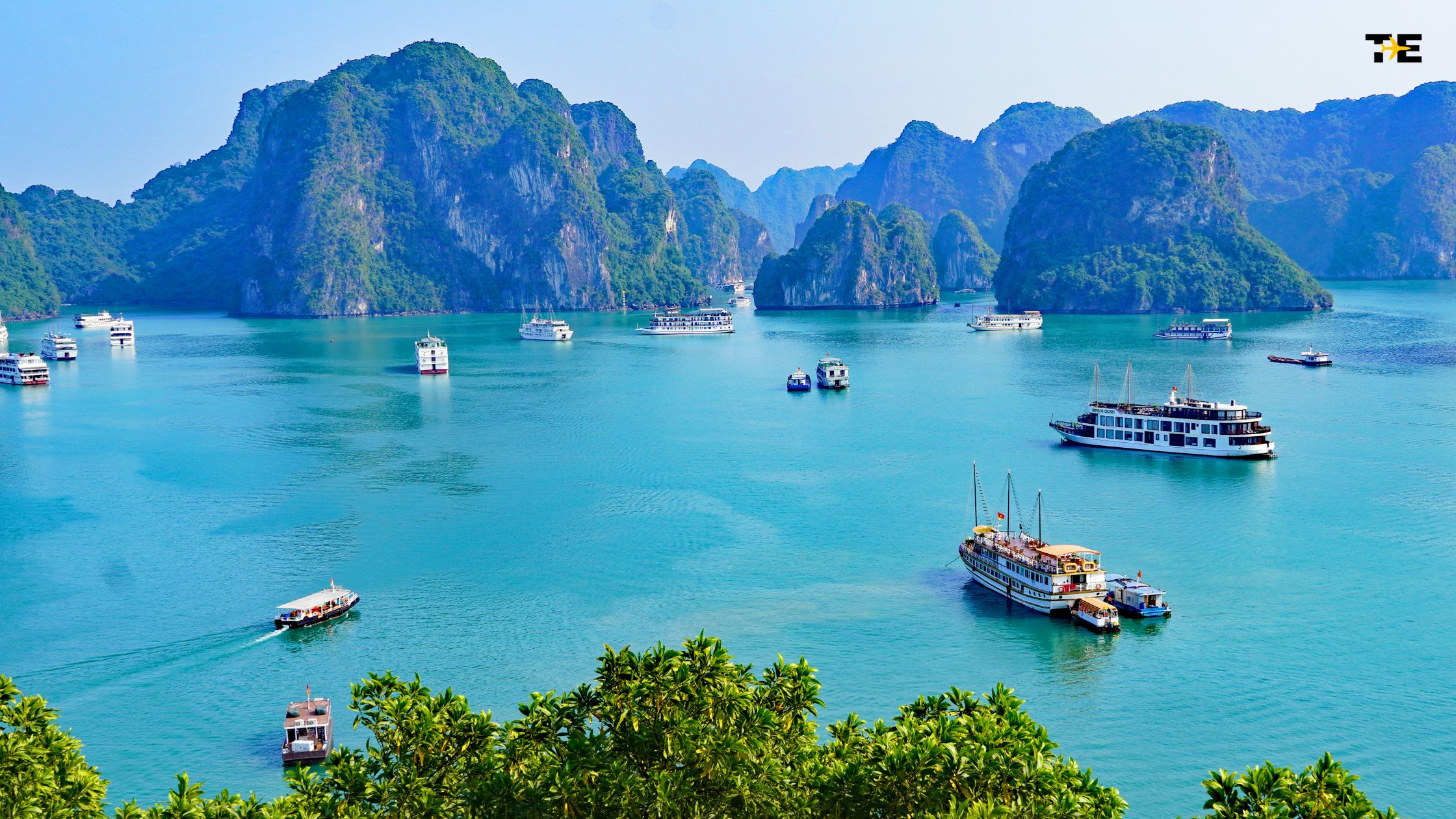Tranquil bay with limestone karsts and boats, showcasing Southeast Asias stunning natural beauty.